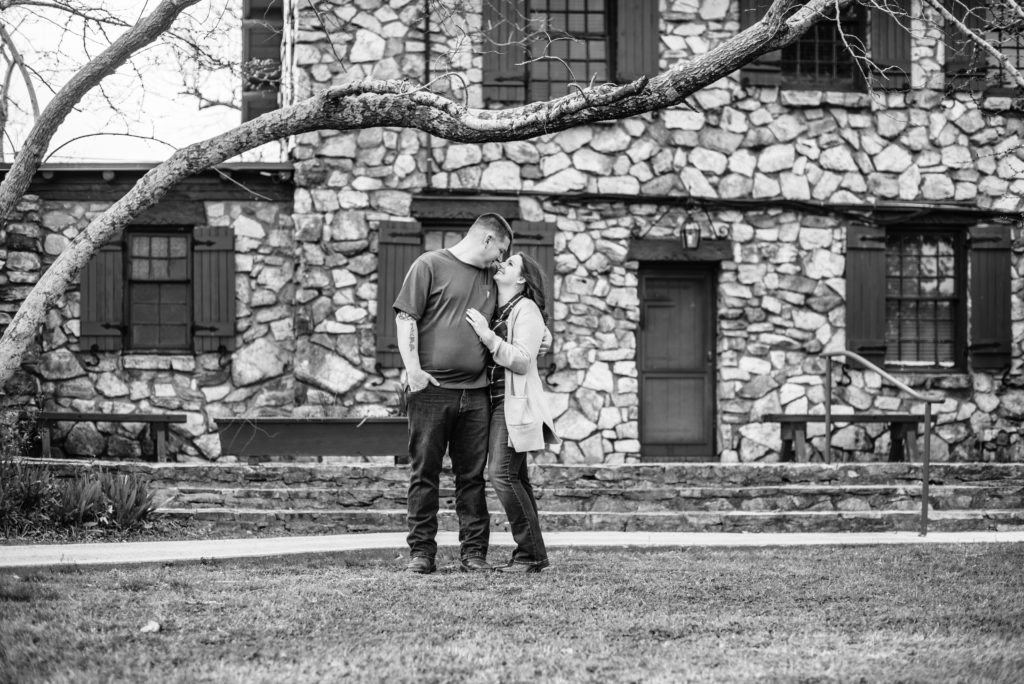 Black and white image of couple wearing green at their engagement session on mountain top at FD Roosevelt State park