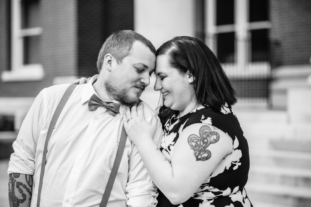 Black and white image of couple cuddling on court square in Newnan GA